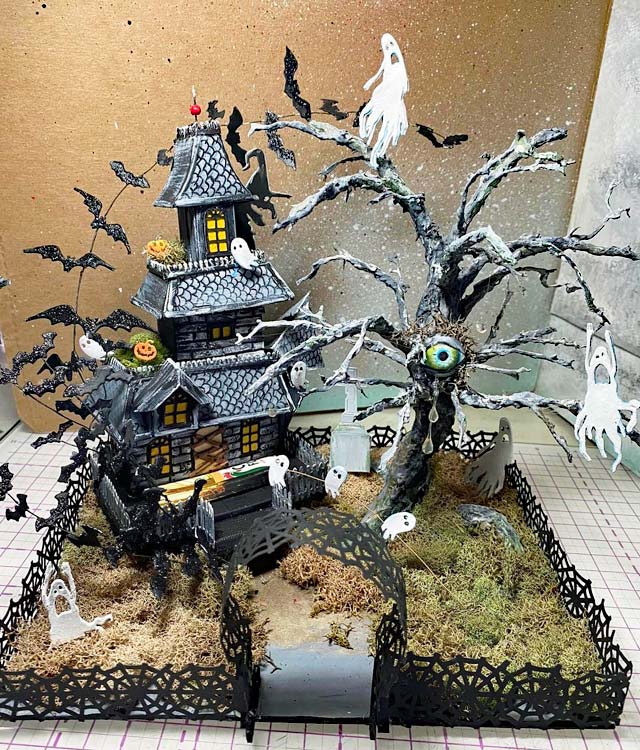 Spooky miniature house with eerie tree with an eye on it