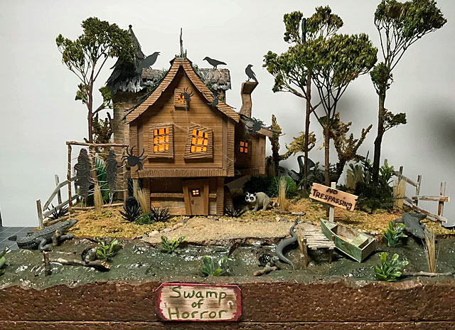 Brown cardboard house on a swamp surrounded by reptiles