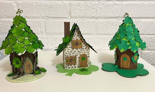 3 paper fairy houses with shamrocks and clovers on roof