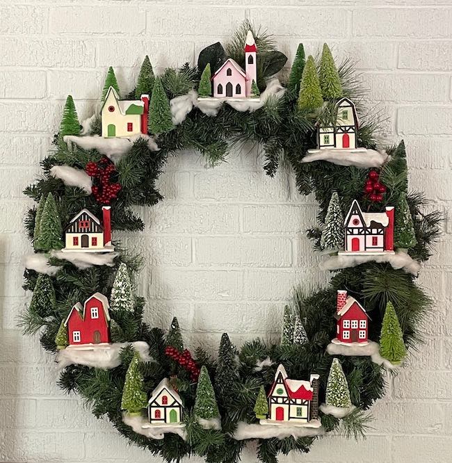 Alpine Village Christmas wreath on white brick