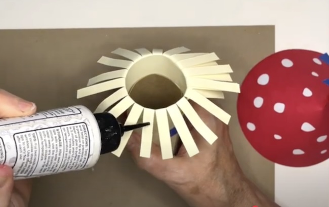 Apply glue to fringe to adhere mushroom cap