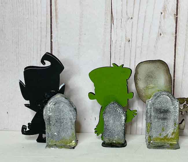 Back of paper figures glued to tombstones