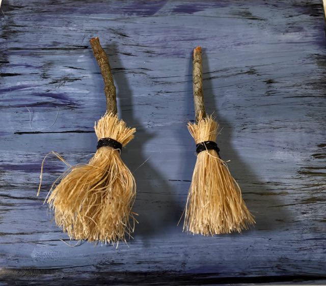 Tiny handmade DIY brooms on blue background