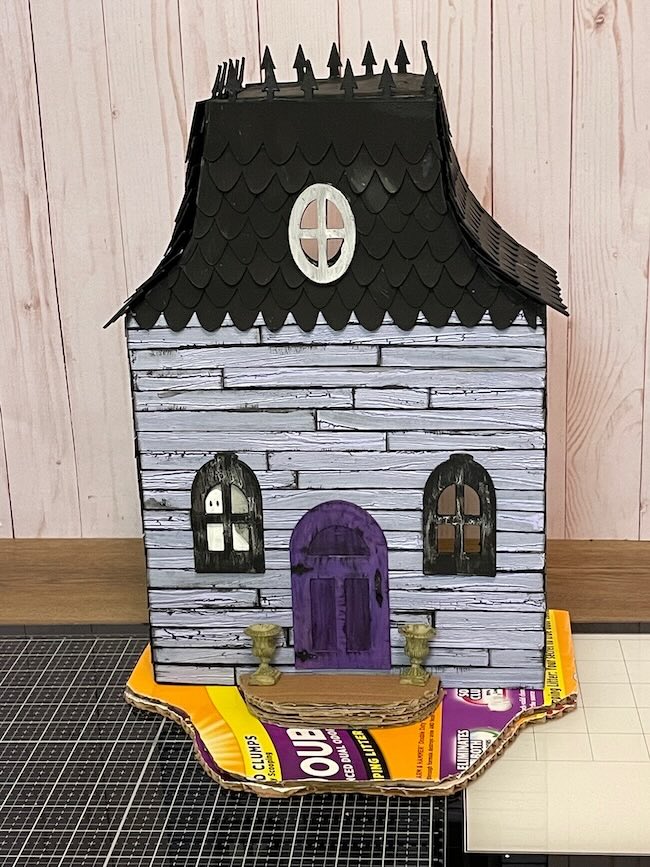 Coated corrugated cardboard below Halloween dollhouse