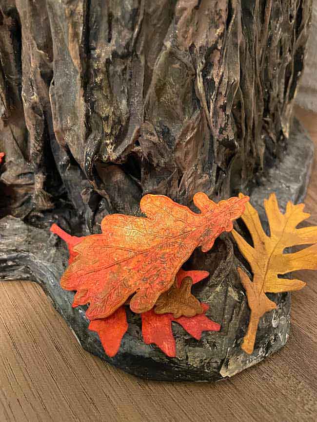 Colorful paper leaves at base of paper mache tree stump