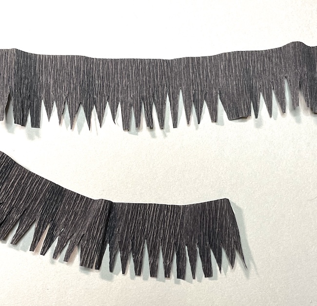 Cut crepe paper to mimic vulture feathers