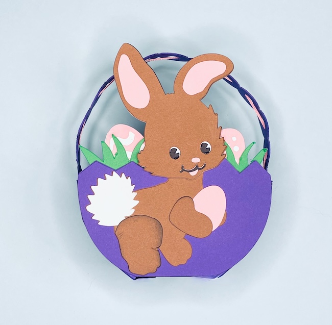 Cute bunny in front of purple candy basket