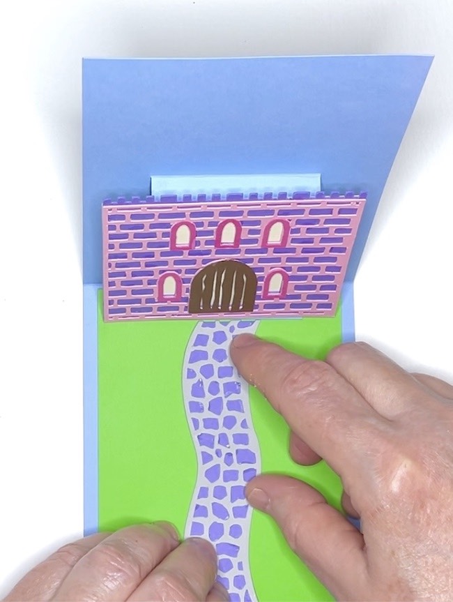 Glue pathway in place on green lawn of pop-up card