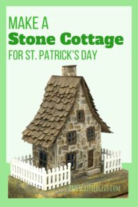 Tiny stone cardboard cottage on green background