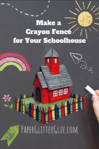 Little red schoolhouse and crayon fence on chalkboard