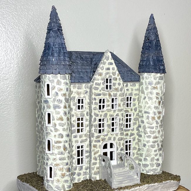 Cardboard castle with dark roof and grey stones
