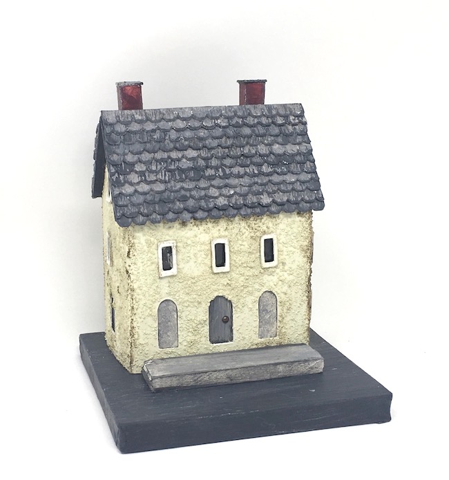 Miniature plaster house covered with fine stone granules