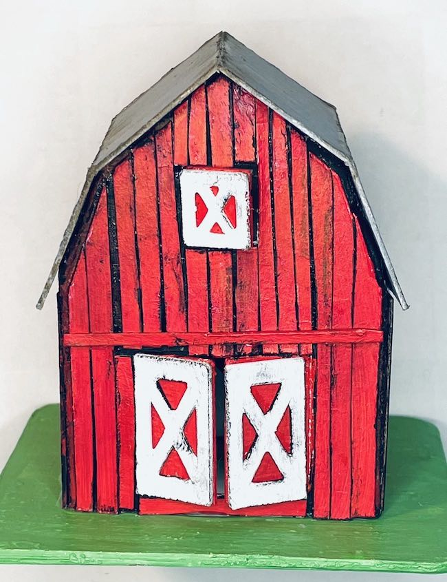 Miniature red barn with vertical siding