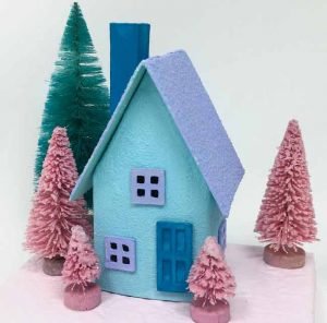 Tiny blue paper house with pink bottlebrush trees