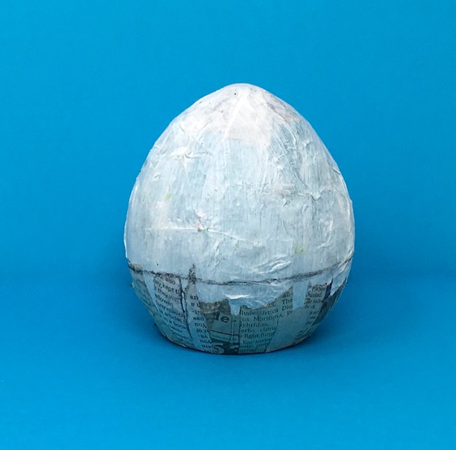 Flat base on paper mache egg with line for cutting the egg into 2 pieces