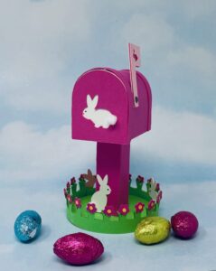 Pink bunny mailbox with chocolate candy eggs at base