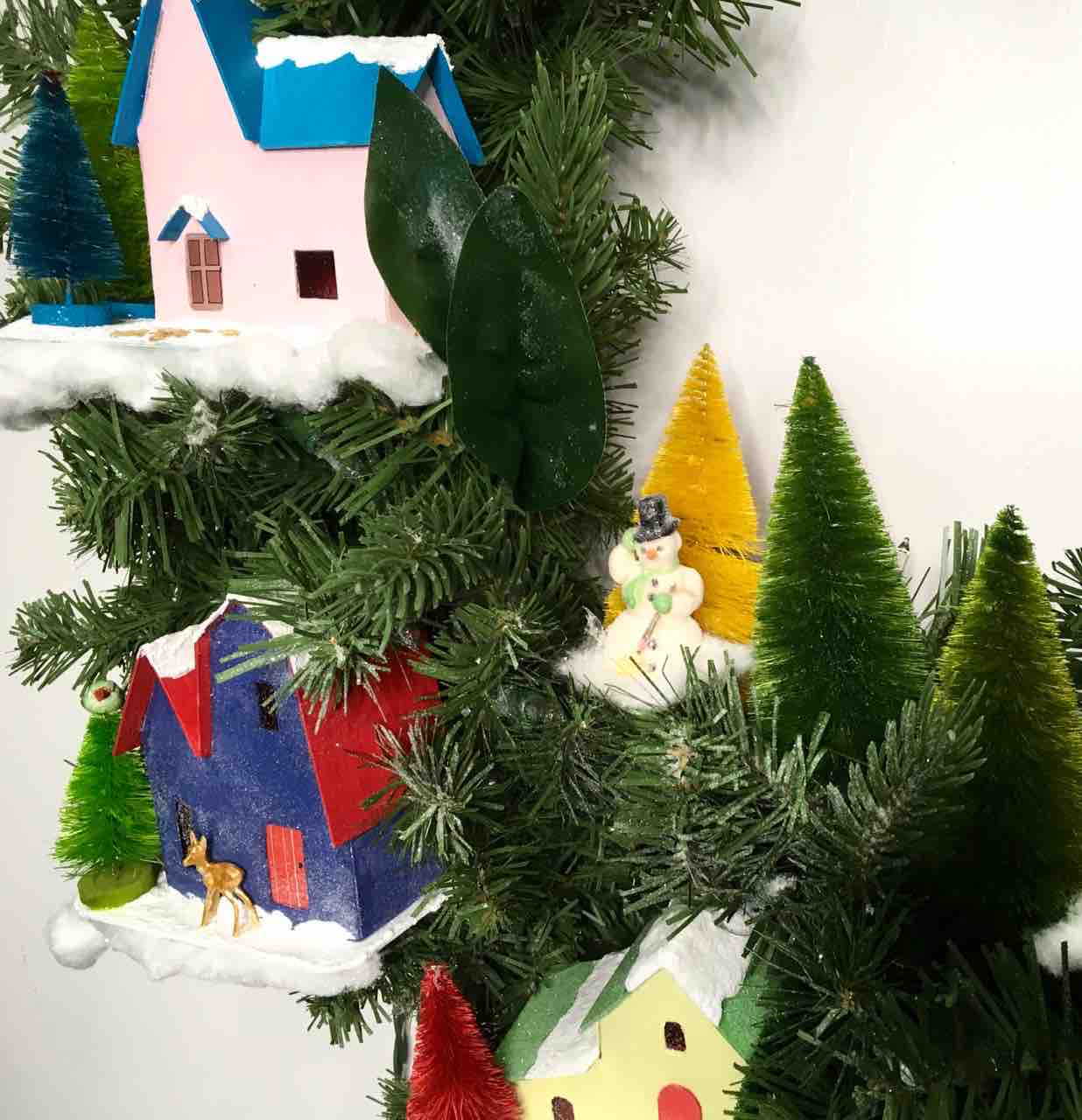 Salvaged Snowman on Winter Village Christmas wreath among bottlebrush trees
