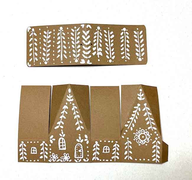 Tiny chalet paper house christmas ornament decorated with white gel pen