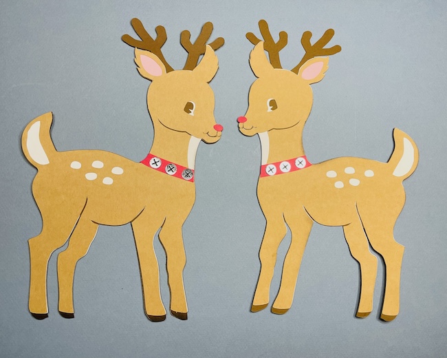 Two paper reindeer figures on blue background