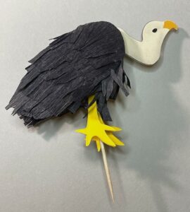 Vulture cake topper on grey background