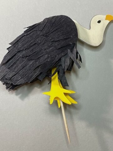 Vulture cake topper on grey background