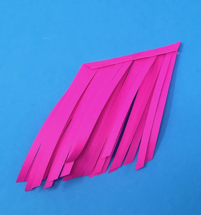fold the top edge of paper over to the fringe