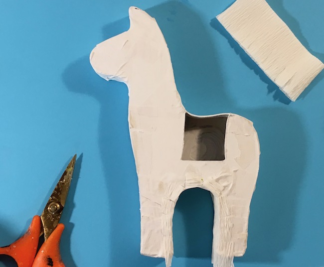 glue fringe to llama pinata form inside legs