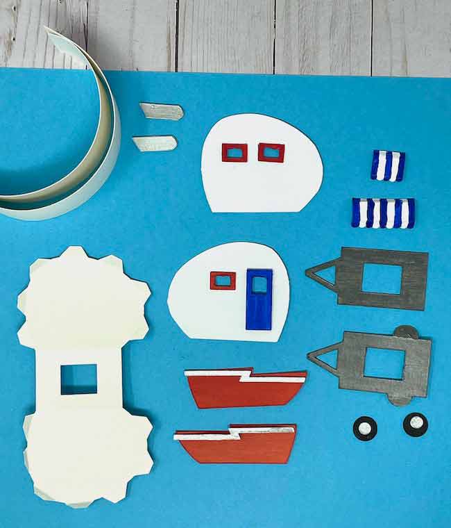 all the cut out pieces to make a tiny camper trailer including painted decorative pieces